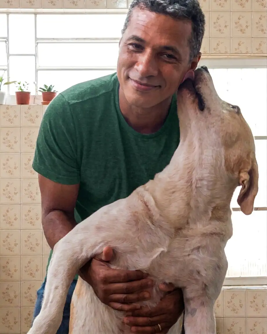 Tio Edson com cachorro Bob no colo recebendo carinho
